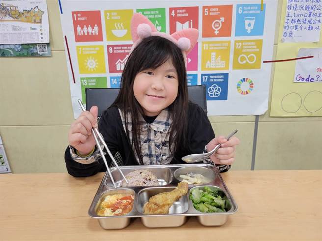 嘉義市文雅國小小朋友今天開心吃營養午餐有蛋料理及雞腿肉。（嘉義市教育處提供／ 廖素慧嘉市傳真）