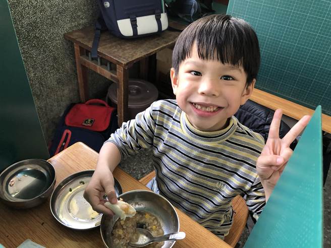 崙背國小學童開心享受影養午餐，今天吃的是含蛋的玉米蔬菜粥。（周麗蘭攝）
