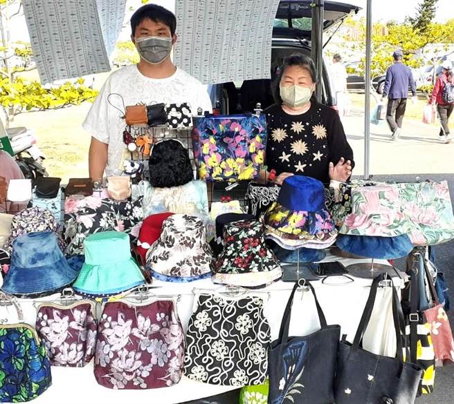 晴天坊成员吴淑莉（右）带着儿子（左）到现场实作，并分享作品给顾客。（台南市政府劳工局提供／张毓翎台南传真）