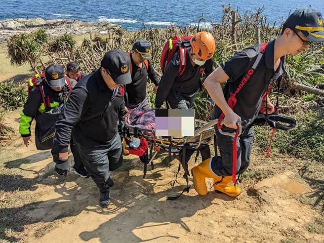 新北市瑞芳区鼻头角步道有一名妇人不慎摔伤左脚踝骨折，消防队员为妇人固定骨折后，使用篮式担架搬运送医。（新北市消防局提供／徐佑升新北传真）