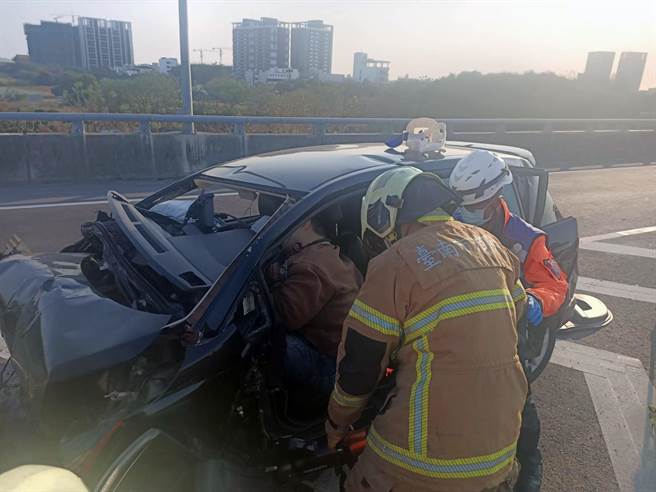 台86线东向湾里出口匝道发生疑似自小客车自撞车祸，救护人员动用破坏器材协助驾车的34岁黄姓男子脱困。（读者提供／洪荣志台南传真）