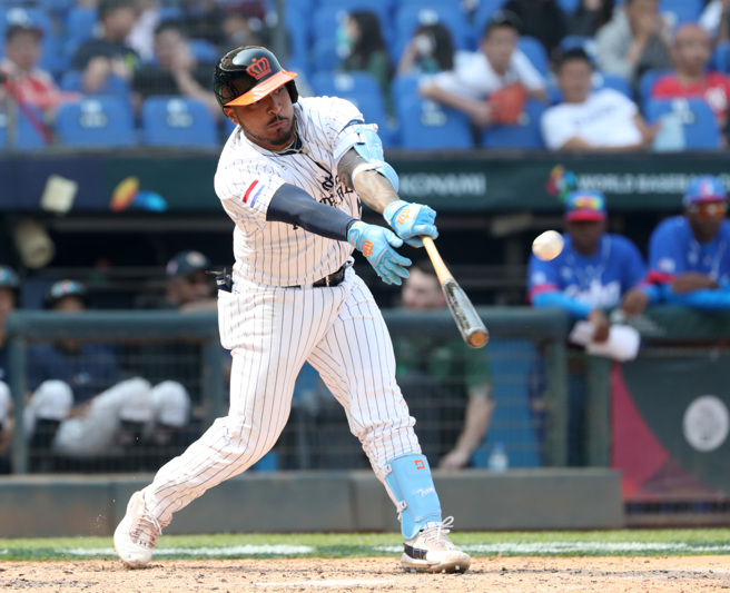 荷兰队川普对古巴在6局下巧妙碰出三不管地带的德州安打。（郑任南摄）