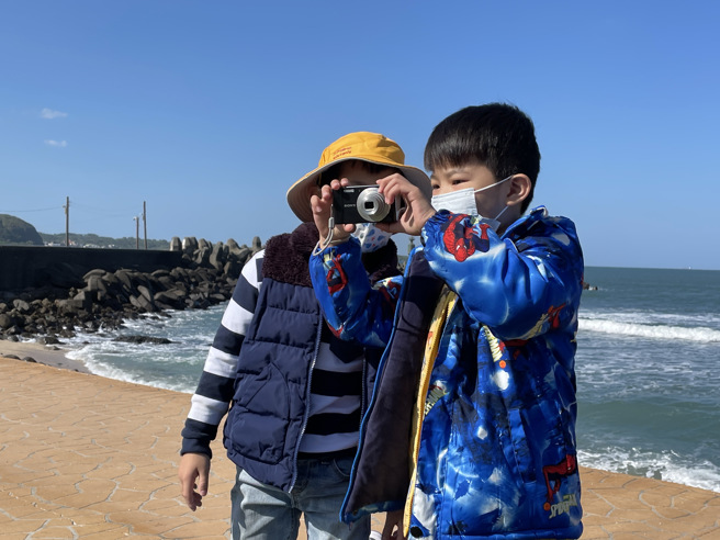 踏查时，幼儿拿着相机记录石门之美。(照片/新北市教育局提供)