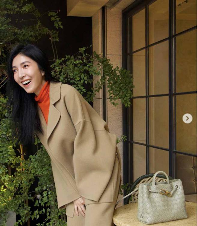 杨谨华以驼色大衣搭配Bottega Veneta Andiamo 深绿色编织皮革中型手提包 ，15万800元。（摘自杨谨华IG）