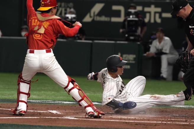 日本跑者近藤健介（右）1局下硬闯本垒，被大陆队捕手李寧触杀出局。（美联社）