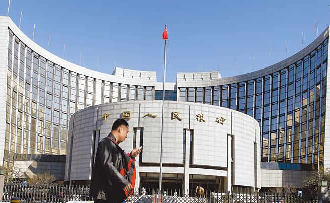 大陆金融监管体系出现重磅变革！大陆将组建国家金融监督管理总局、不保留银保监会；推进人行分支机构改革等变化，让「一行两会」时代宣告落幕。图为一位正在看手机的年轻人走过北京中国人民银行总部。（中新社）