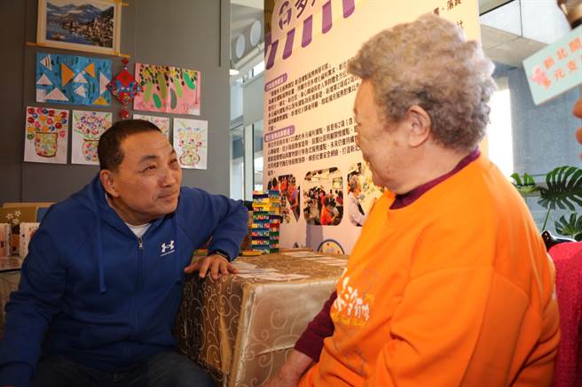 新北市侯友宜关心今年89岁的阿嬷在芦洲新希望社区关怀协会据点活动的情形，盛讚阿嬷头脑清晰。（新北市社会局提供）