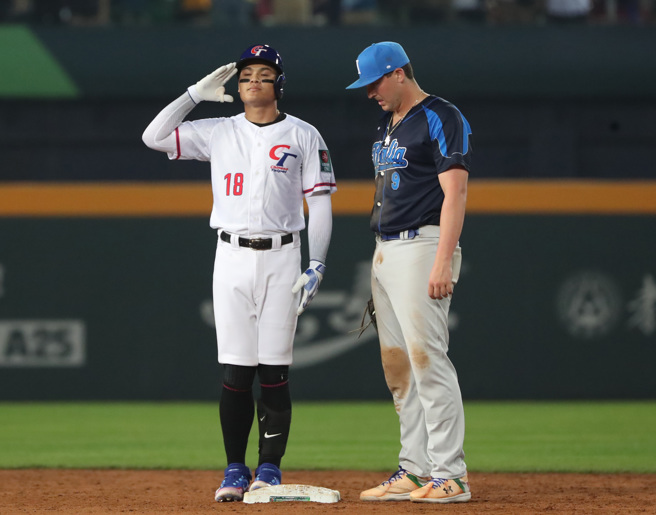 張育成（左）敲出二壘安打，再度秀出招牌敬禮手勢。（鄭任南攝）