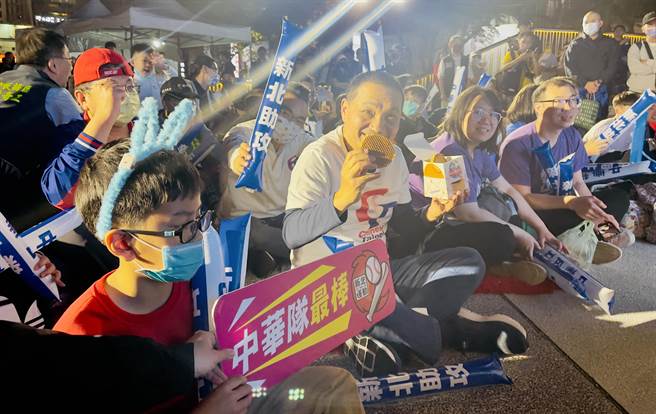 现场大小球迷们拿到煎饼都笑得合不拢嘴。（吕健豪摄）