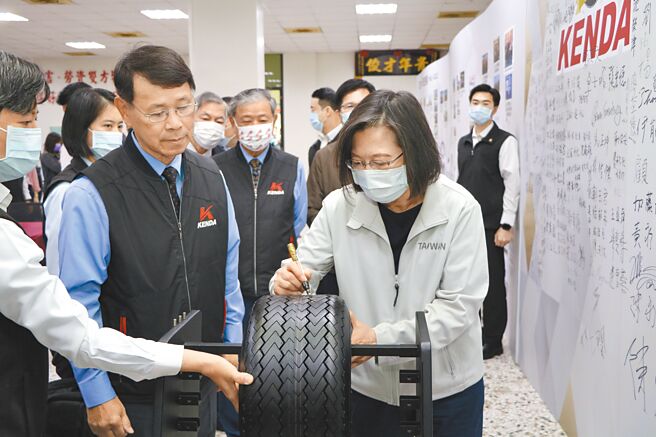 总统蔡英文（前排右一）10日在建大董事长杨启仁（前排左二）的介绍下，特地在建大生产的高尔夫球车胎上，签名留念。图／刘朱松