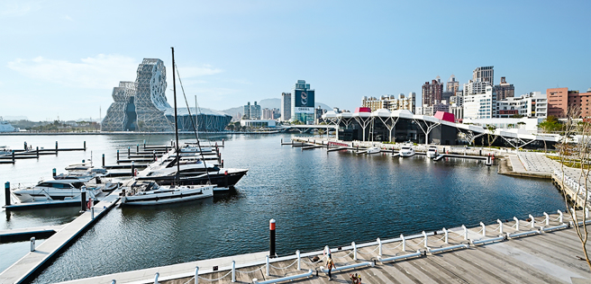 登上鯨魚堤岸的綠化景觀台，可見高雄流行音樂中心的音浪塔、珊瑚礁群及遊艇碼頭。(攝影/Carter)