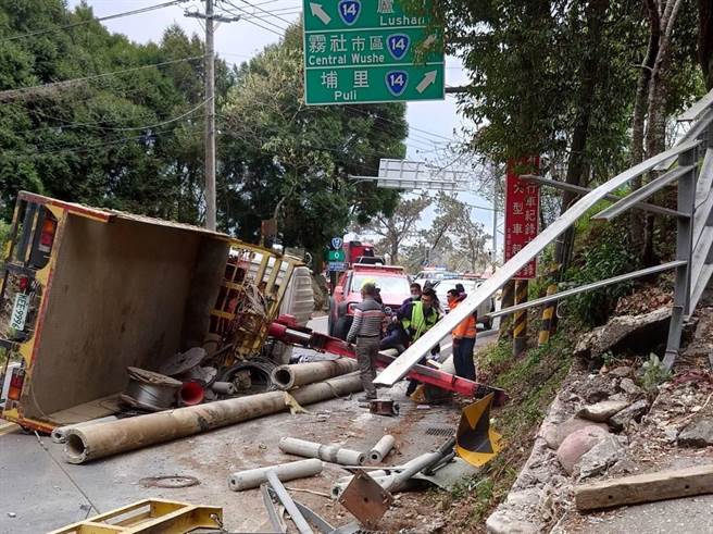 黃姓男子駕駛吊臂拖板車載運水泥電桿，行經台14甲線仁愛鄉衛生所右轉彎路段不慎翻覆。（民眾提供／楊靜茹南投傳真）