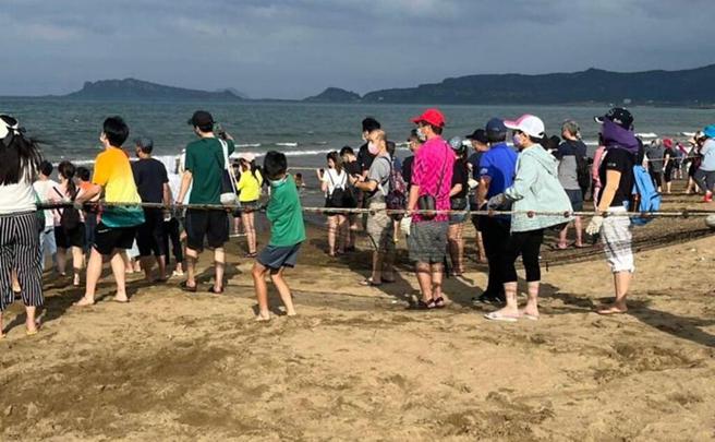 民眾在沙滩体验「牵罟」活动。（图／新北市政府观光旅游局提供）