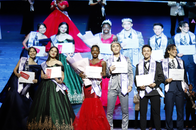 获国际文化大使男子组冠军厨艺学系印尼侨生黄建智(右三)，以及女子组冠军学士后医学系来自圣露西亚的塔妮卡(左三)，亮眼的表现，过关斩将夺下宝座。(照片/义守大学提供)。