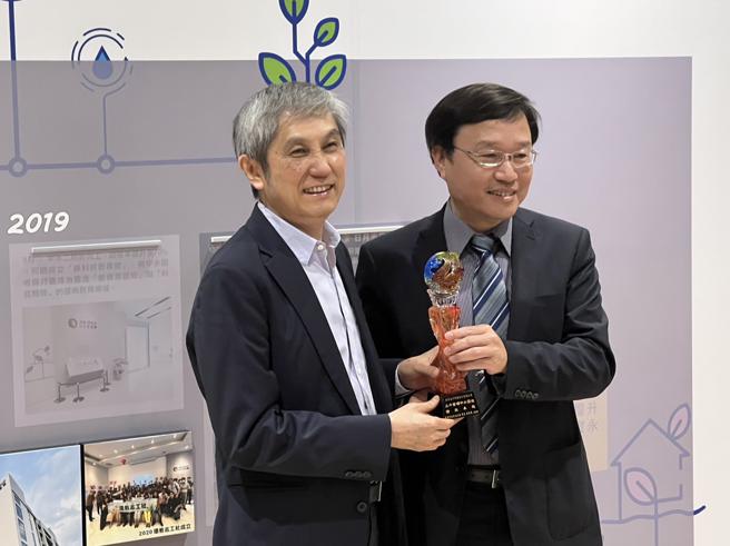 高市水利局长蔡长展（右）致赠奖座给日月光高雄厂总经理罗瑞荣（左）。（高雄市水利局提供）