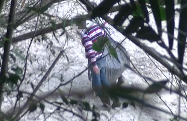 嫌犯从水库上游驾驶胶筏至滩地上岸，还从胶筏上挑下1个沉重的黑色太空包。（翻摄照片／蔡明亘桃园传真）