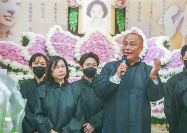 伍宗德（拿麦克风者）以孝女婿身分代表周家致词，左为双眼哭肿的周雅芳。（粘耿豪摄）