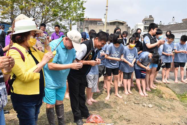 苑里镇农会新一期彩绘稻田，17日完成插秧，农会理事长吕联庆带着小朋友们一起祭拜田头伯公。（谢明俊摄）
