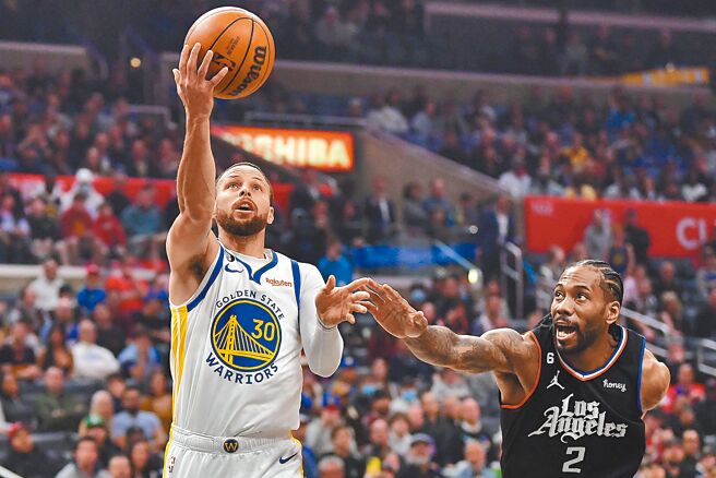 勇士射手柯瑞（左）右手挑篮，快艇前锋里欧纳德阻止不及。（路透）