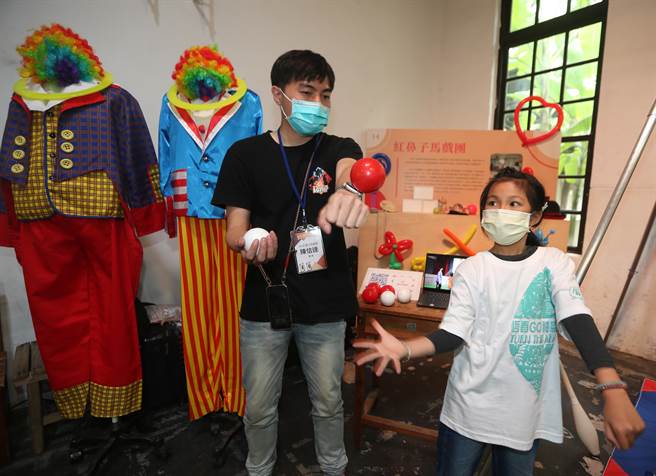 「文化体验教育展」开幕记者会，红鼻子马戏团团员现场传授小朋友丢球的技巧。(陈怡诚摄)