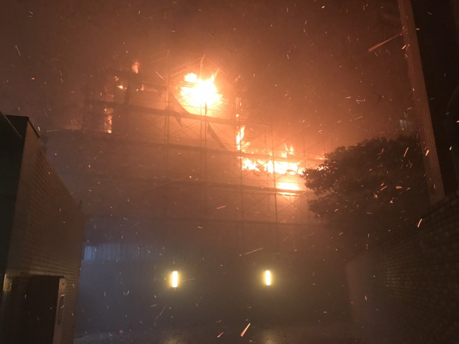 新北林口工地火警，烈焰照亮夜空警消抢救。（简铭柱翻摄）