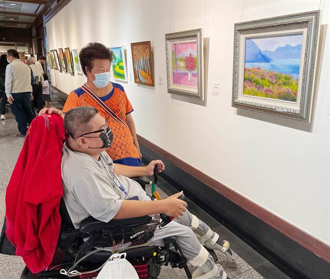 一路陪伴江永旭的母亲（左）看到儿子的画作，眼神满是欣慰。(慈济医院提供)