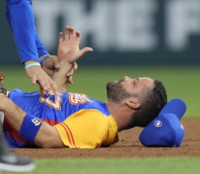 委内瑞拉二垒手艾尔图维被触身球打倒在地。（美联社）