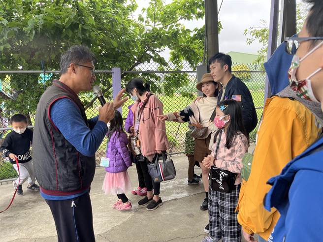 山脚鹿场水鹿之家二代园主郑文彬（左）向游客进行导览解说。（陈梦茹摄）