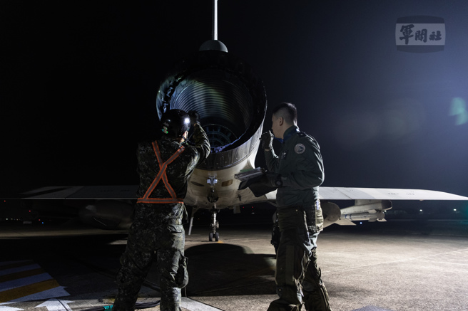 清晨天仍未明，飞行官与地勤人员对战机实施360度检查，确保飞行安全。（军闻社提供）
