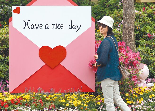 新冠肺炎轻症免隔离20日上路，中央流行疫情指挥中心公布新增5411例本土病例，估计下周可能大降至400例。图为民眾昨前往北市大安森林公园赏花，开心拍照留念。（赵双杰摄）