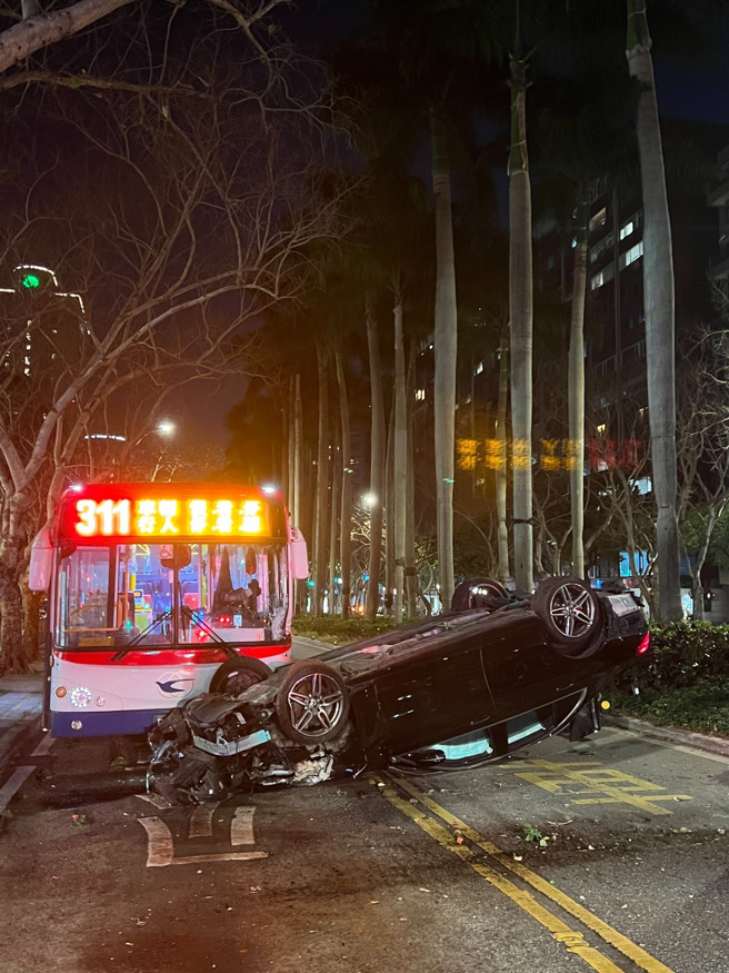 北市宾士车飞越分隔岛撞公车，驾驶一度受困吓坏乘客。（简铭柱翻摄）