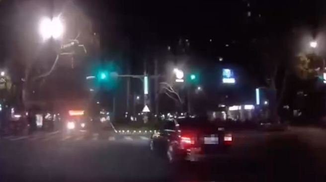 北市1輛酒駕賓士車駕駛突爆衝，直接撞斷中央分隔島上的「百萬」大王椰子樹。（翻攝影片）