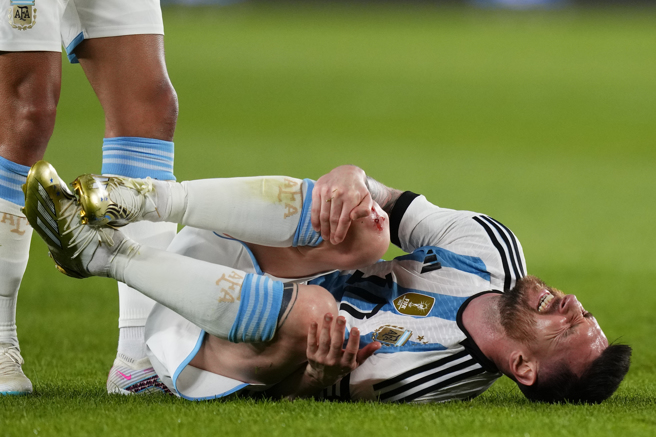 梅西遭巴拿馬球員鏟傷，膝蓋流出血來。（美聯社）