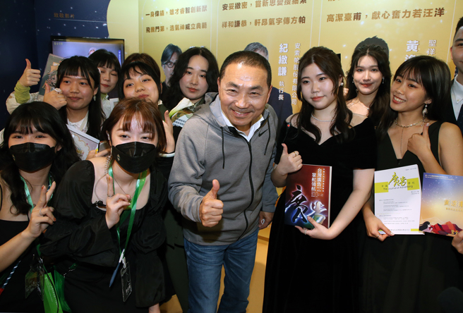 新北市长侯友宜（前中）24日受邀出席中国文化大学广告学系毕业展，参观各组学生毕业制作时，受到大家热烈欢迎，争相要求合影留念。（赵双杰摄）