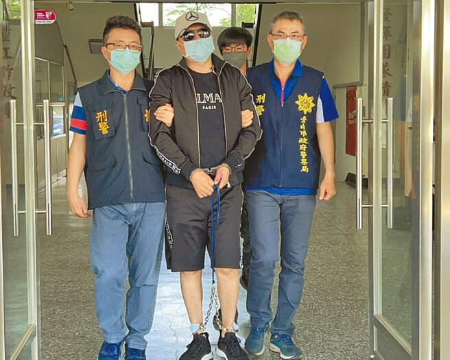 「菲国军火大亨」陈建寧(中)被押解回台南市刑大，23日下午解送嘉义地检署归案。（张毓翎摄）