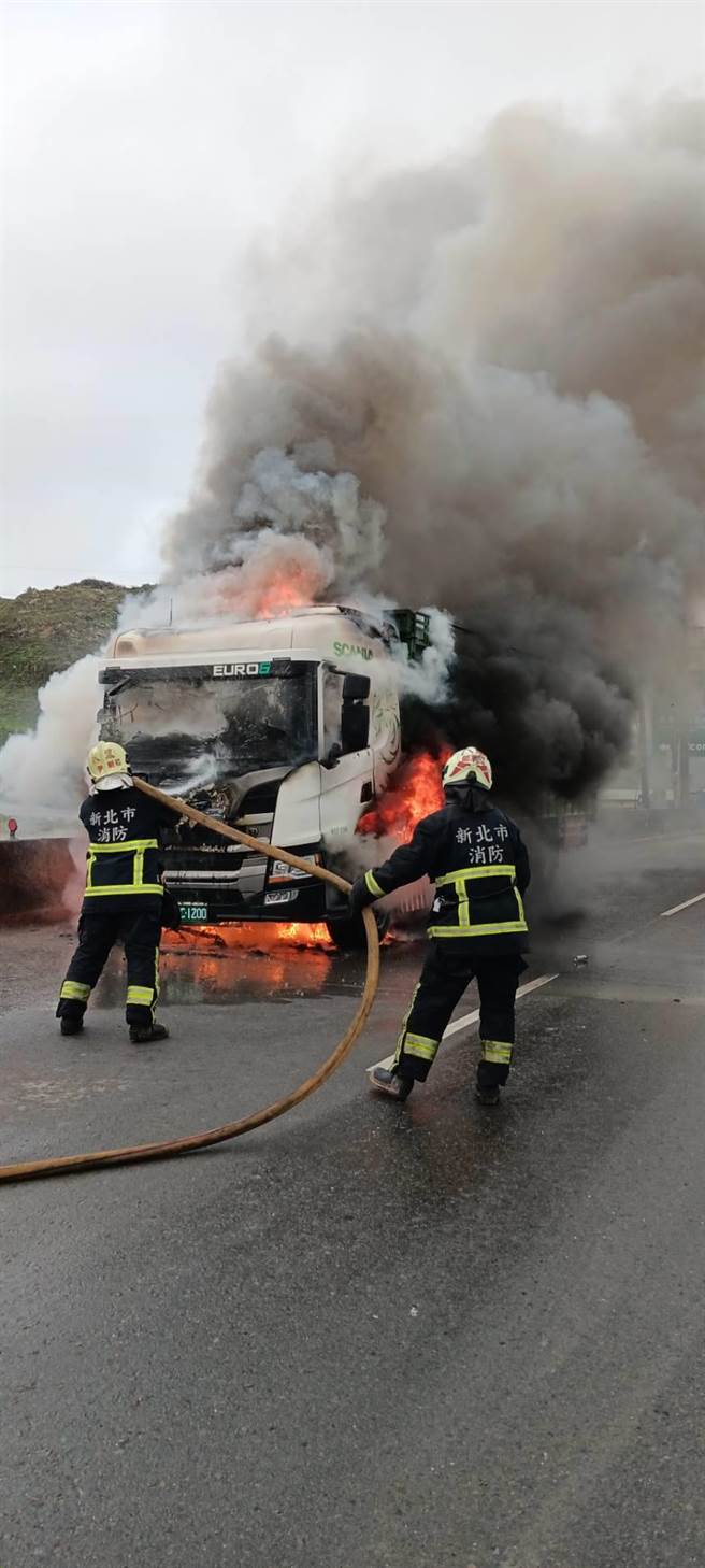 大貨車不但車頭竄出火舌，濃煙也不斷直衝天際。（消防局提供）