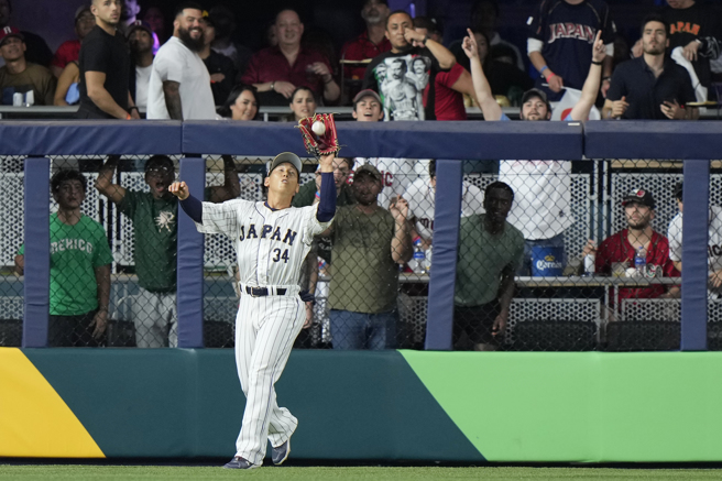 吉田正尚在全垒打墙前接杀飞球。（美联社资料照）