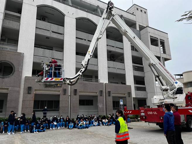 金门消防人员于金门高中办理校园消防体验活动，现场出动云梯车演练救灾状况，师生迴响热烈。(图／金门县消防局提供)