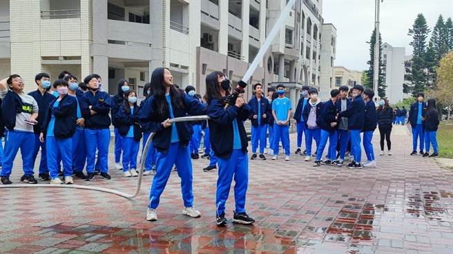 金门高中学生亲自下场体验消防员射水救灾实务，将各种消防安全知识深植于心。(图／金门县消防局提供)