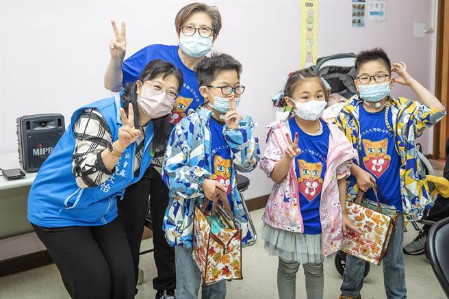 郭姓雙胞胎兄弟和妹妹率先完成全家福彩繪創作，社會處長陳欣怡（左）頒發小禮物。（羅浚濱攝）