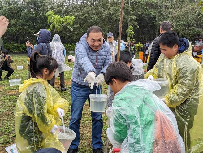 新北市长侯友宜26日与在地的学童共同种下茄冬树，宣告「陆海空植树」计画启动。（张志康摄）