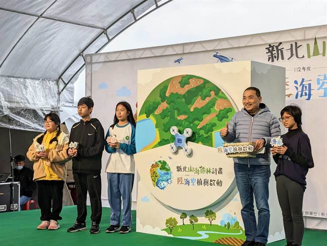 新北市长侯友宜（右2）26日与在地的学童共同种下茄冬树，宣告「陆海空植树」计画启动。（张志康摄）