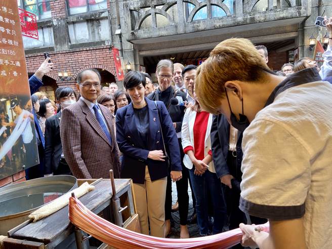 一行人欣赏糖葱制作过程。（吴佩蓉摄）