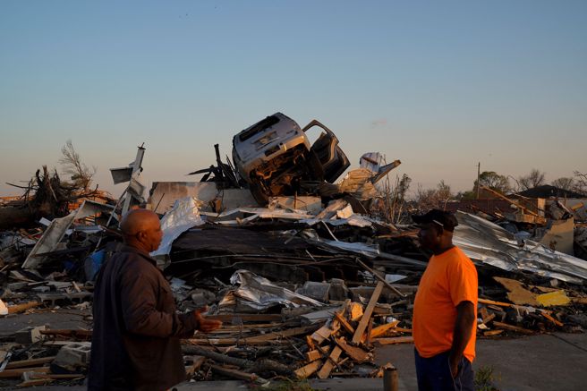 風災過後，密西西比州羅靈福克鎮盡是殘破景象，災民一臉沉重。被龍捲風颳上半空中的汽車落在全毀的屋瓦上。（圖／路透社）