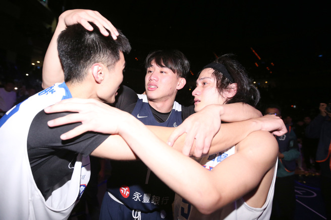111学年度富邦人寿UBA大专篮球联赛公开男一级冠军战26日开打，政治大学击败对手健行科大，夺下冠军，政大的林彦廷（中）一开赛就伤退，比赛结束后他激动落泪，和同样毕业自能仁家商，目前在健行科大的高锦玮（右）、丁冠皓（左）相拥打气。（黄世麒摄）