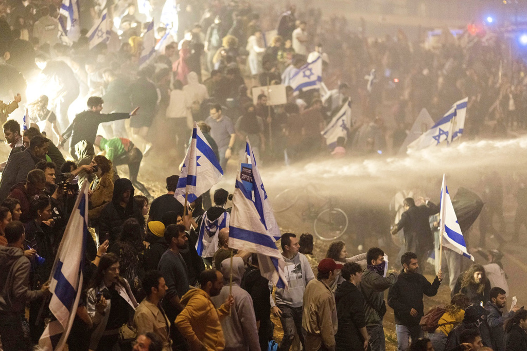 上万以色列人26日深夜霸占特拉维夫一座高速公路抗议，遭到警方以强力水柱驱逐。（图／美联社）(photo:ChinaTimes)