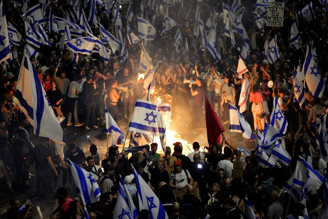 上万以色列人26日深夜霸占特拉维夫一座高速公路抗议，在公路上燃烧废弃物。（图／美联社）