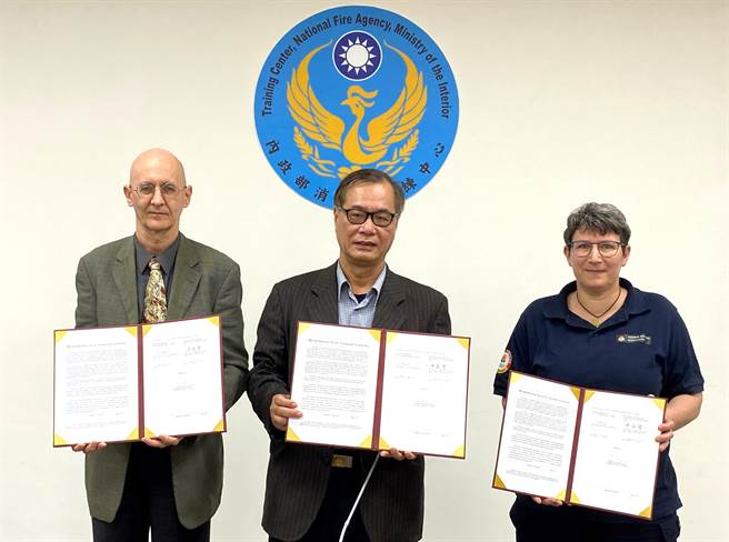 消防署特搜队长陈义丰（中）与德国联邦救难犬协会代表（右）签署MOU，德国在台协会代表许佑格代表（左）见证。（消防署提供）