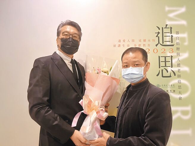 受赠者代表倪嘉元（左）献花给捐赠者周奕翔的父亲周竣源（右）。（陈梦茹摄）