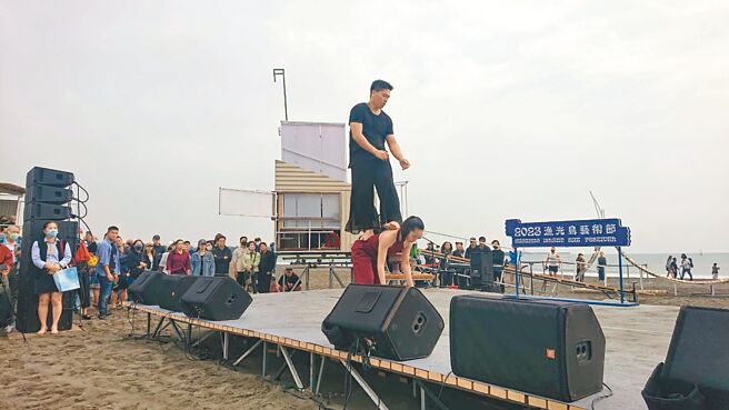 台南市安平漁光島藝術節大批民眾圍坐在沙灘上看表演。（程炳璋攝）